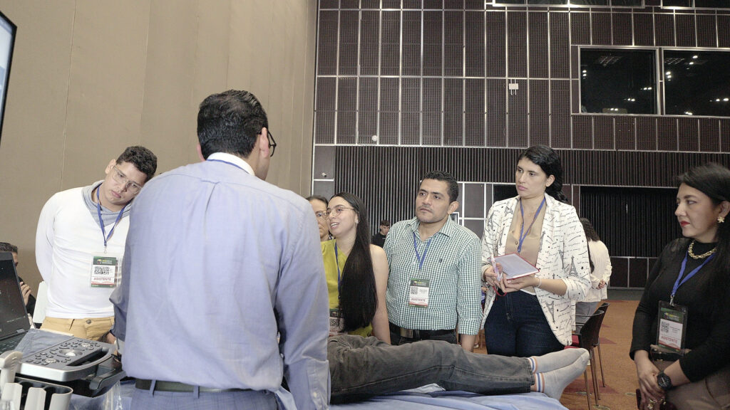Grupo de asistentes alrededor de la camilla en el taller de ecografía.