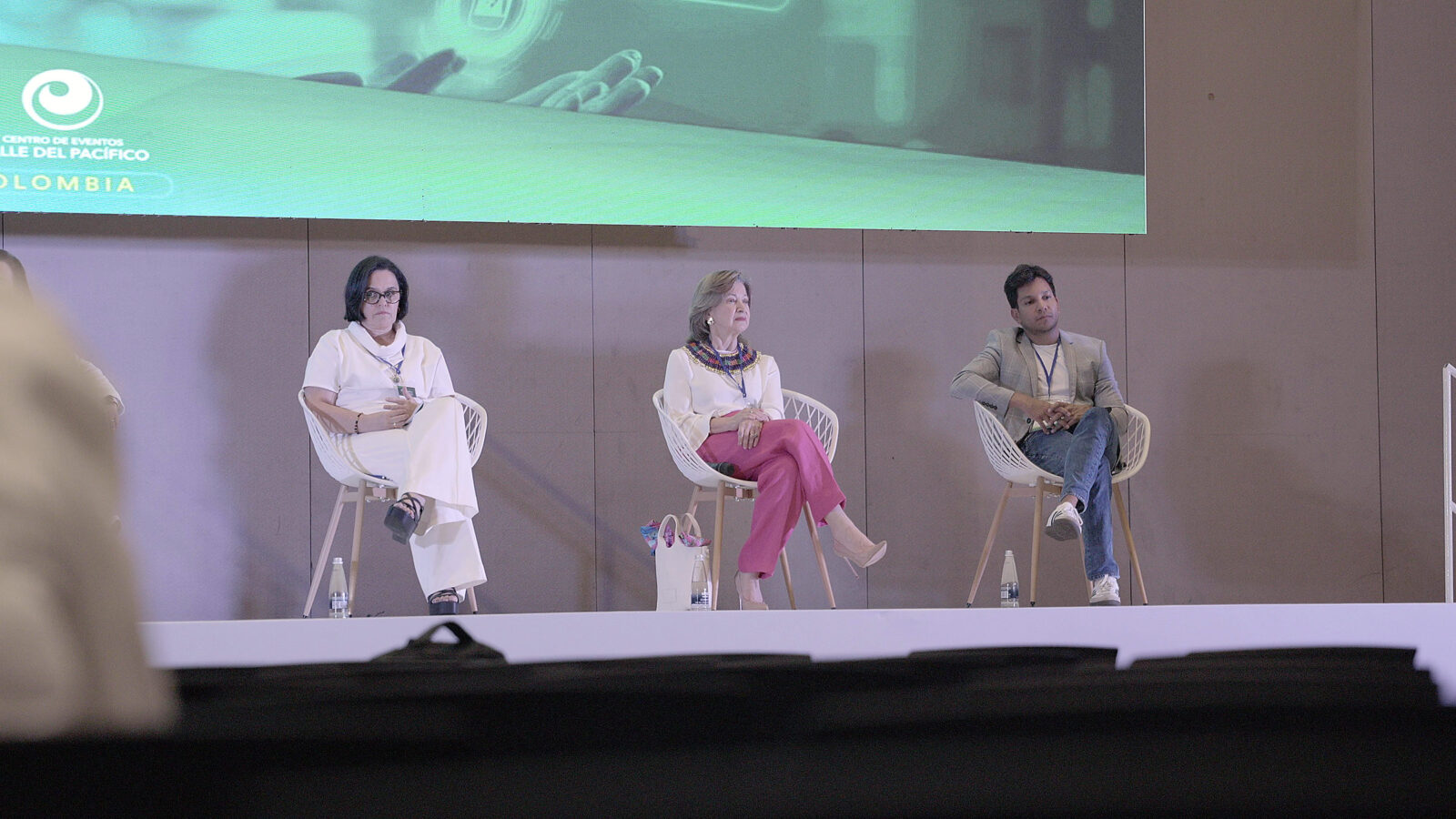 Panel de conferencistas en el escenario durante una intervención.